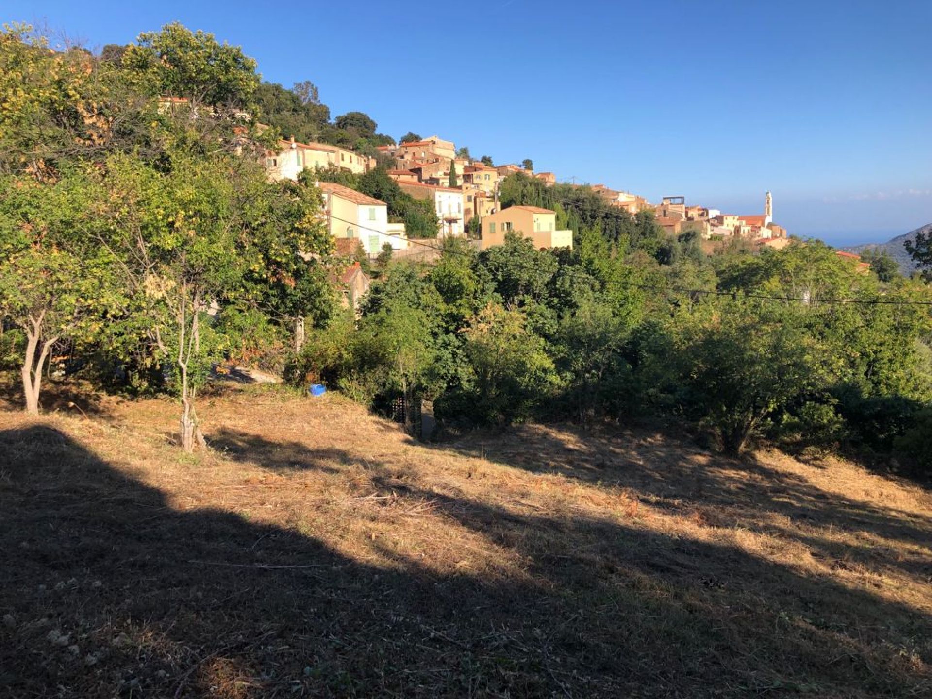 Terrain vue dégagée sur le village, la plaine, la mer et la montagne